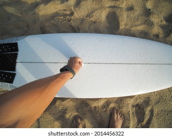 POV View  Male Hand Waxing White Surfboard On The Surf Beach. Surfing Concept.