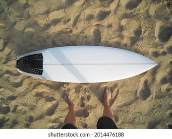 POV View Of A Man Stands Next White Surfboard On The Sandy Beach. Surfing Concept.