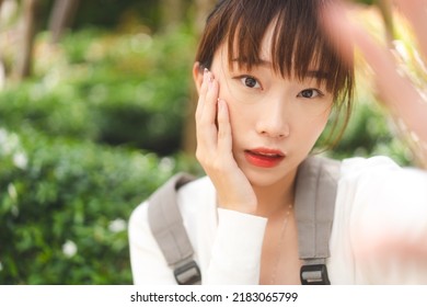 POV View Portrait Of Young Adult Cute Asian Student Woman Take A Selfie Photo By Mobile Phone. Beauty Face Infuencer College People Lifestyle For Social Media Concept. Eye Looking Camera.