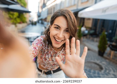 POV view portrait of young woman blogger taking selfie on smartphone, communicating video call online with subscribers, recording stories for social media vlog outdoors. Girl walking in city street - Powered by Shutterstock