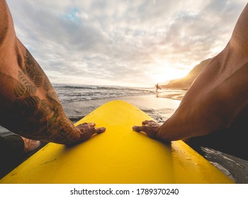 Pov view of tattoo surfer waiting waves on tropical beach - Fit atlhete having fun doing extreme water sports - Travel and healthy lifestyle concept - Main focus on left hand