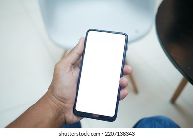 POV of young man hand using smart phone with empty screen sitting on chair  - Shutterstock ID 2207138343