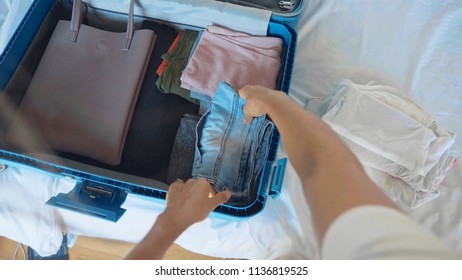 POV Of Young Woman Is Collecting A Suitcase. The Traveler Preparing For Journey, Personal Perspective View.