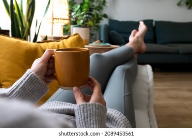 POV Of Young Woman Relaxing At Home With Cup Of Coffee Lying On Couch.