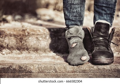 Poverty concept. Poor woman wearing tatter sock and one boot - Shutterstock ID 666582304