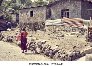 Poverty In Latin America / Poor Woman Walking On Dusty Road In Mexico / Colorful Latin Clothing