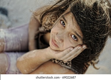 Poverty And Poorness On The Children Face. Sad Little Girl. Refugee. War Results.