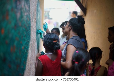 POWAI, MUMBAI, MAHARASHTRA, INDIA - OCTOBER 16, 2017 - A social worker/ artist is seen painting a wall in a chawl area, as part of a clean up initiative taken up for the rehabilitation of slum kids.