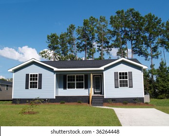 Powder blue low-income single-story home with porch.