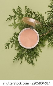 Powder Box With Fir Sprig On A Green Background. Natural Cosmetics Concept. Top View