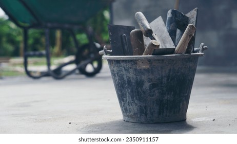 Powder Cement and sand mixing bucket tank, trowel, and plastering equipment in construction site.  - Shutterstock ID 2350911157