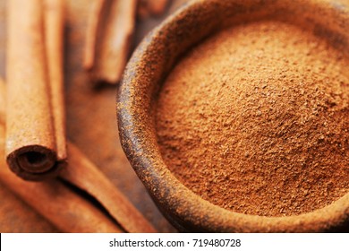 Powder Cinnamon And Sticks And On Brown Rustic Background. Aromatic Spices.