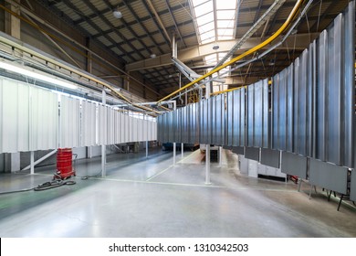 Powder Coating Line. Metal Panels Are Suspended On An Overhead Conveyor Line. Painting Products In An Electrostatic Field.