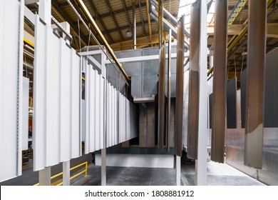 Powder Coating Line. Metal Panels Are Suspended On An Overhead Conveyor Line. Painting Products In An Electrostatic Field.