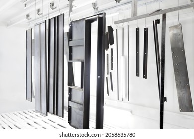 Powder Coating Of Metal Parts In Spray Booth. Coating Industry Painting Metal Products In Paint Booth. Factory Metal Surface Coating Paint In Painting Chamber. Steel Parts Inside Industry Paint Garage