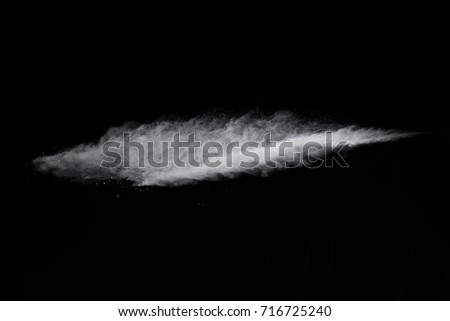 Powder explosion. Closeup of white dust particle explosion isolated on black background