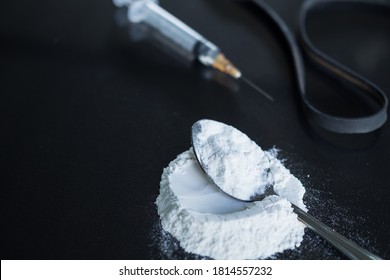 powder morphine on spoon and morphine in syringe with black rubber band on black wood background. Illegal drug. addictive substance, narcotic, habit-forming substance concept. - Shutterstock ID 1814557232