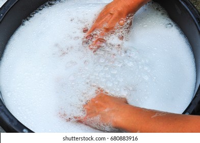 Powdered Detergent.washing Powder.female Hands Washing Clothes In Basin. Wash Clothing By Hand With Detergent. Water Will Wash Over Wash Machine. Hand Washing.selective Focus And Space For Text.