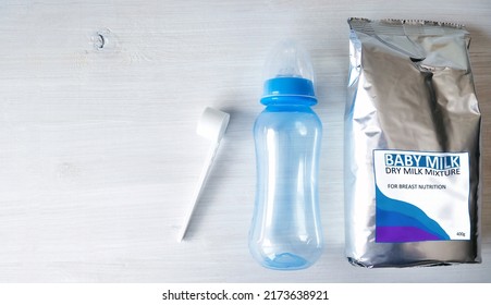 Powdered Infant Formula In A Package, Measuring Spoon, Feeding Bottle With Nipple. Nutrition For Newborns.