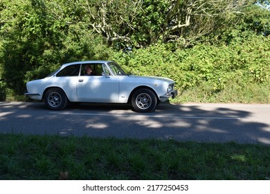 Powderham, Devon, UK. July 9th 2022.  Alfa Romeo 105 Classic Sports Car From The 1960's In White. This Gorgeous Car Is Pictured Driving Down A Country Road In Devon, England.