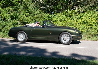 Powderham, Devon, Uk. July 9th 2022. Green MG RV8 Roadster Driving Down A Country Road. A Rare Open Top British Sports Car From The 1990's.