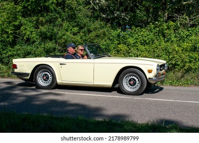 Powderham, Devon, Uk. July 9th 2022. Triumph TR6 Classic Car. White Open Top Sports Car From The 1970's. Collecible English Historic Vehicle. Pictured Driving Down A Country Road On A Summers Day.