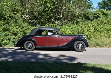 Powderham, Devon, Uk. July 9th 2022. Riley RME 1.5 Classic Car In Dark Red And Black. Elegant Lines And Swooping Difine This 1950's Historic Vehicle. Pictured Driving Down A Country Road On A Summers 