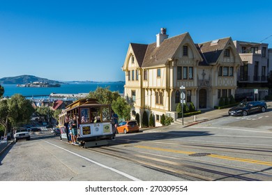 Powell Hyde Cable Car, A Group Of Tourist Attraction, Descends A Steep Hill Overlooking Alcatraz Prison And SF Bay On April 13, 2015 In San Francisco, USA