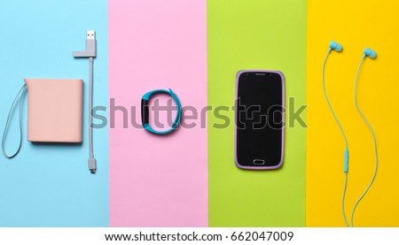 Power bank, smart watches, headphones, smartphone lined on a colorful background. Top View