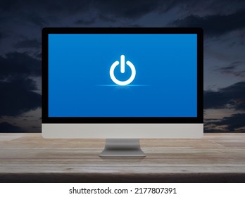 Power Button Icon On Desktop Modern Computer Monitor Screen On Wooden Table Over Sunset Sky, Business Start Up Online Concept