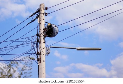 Power cable and fiber internet cable, microphone on electric pole, blue sky background.