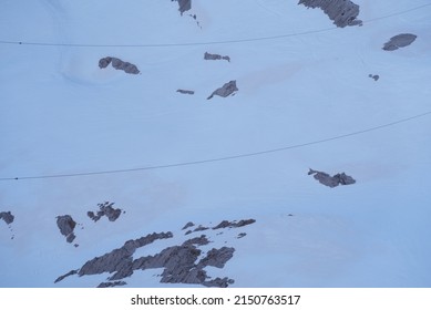 Power Cable At Säntis Mountain With Sahara Desert Dust On Top Of Snow Layer On A Spring Morning. Photo Taken April 19th, 2022, Säntis, Switzerland.