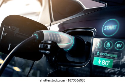 Power cable pump plug in charging power to electric vehicle EV car with modern technology UI control information display, car fueling station connected power cable alternative sustainable eco energy - Shutterstock ID 1873566085