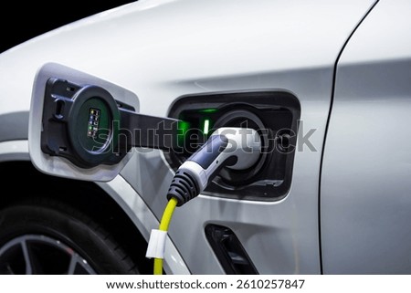 Power cable pump plug in charging power to electric vehicle EV car.