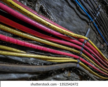 Power cables bundle in old salt mine attached to the underground corridor wall