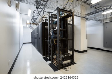 Power cables and computer towers with interconnected wires in server room
