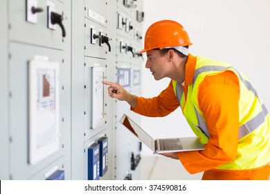 Power Company Technical Worker Using Laptop Computer In Control Room