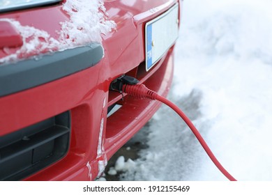 The power cord of the block heater connected to the car engine in winter