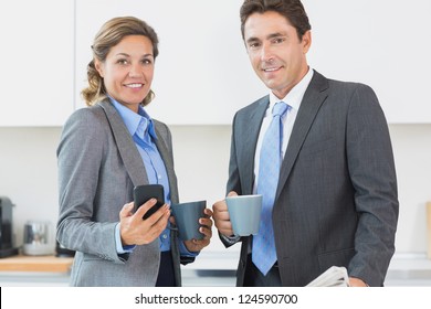 Power Couple Having Coffee Before Work In Kitchen