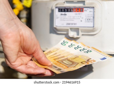 Power Expenses - Hand Giving Money To Energy Supplier On White Background