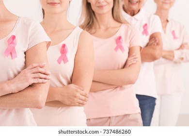 The power to fight breast cancer, women wearing pink ribbons for breast cancer campaign on white background - Shutterstock ID 737486260