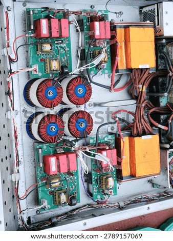 Power filter rack with toroidal coils and control boards. Industrial inverter section with transformers wiring and chokes. Electrical assembly layout for maintenance and troubleshooting