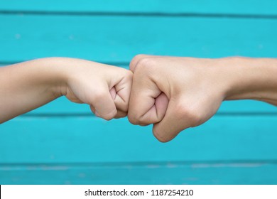 Power Five, Fist Bump Or Brofist. Close-up Of Child And Father Fists Touching Each Other