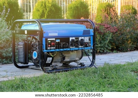 Power generator standing in the garden on the pavement.
