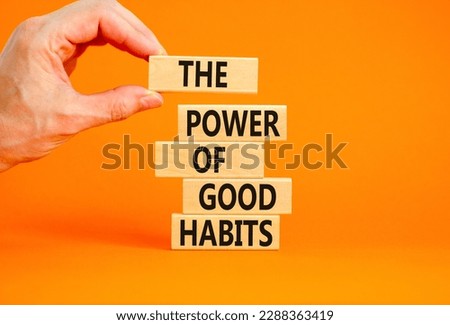 The power of good habits symbol. Concept words The power of good habits on wooden block. Beautiful orange table orange background. Businessman hand. Business power of good habits concept. Copy space.