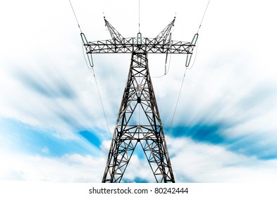 Power Grid Pylon Against Blue Cloudy Sky With Visible Motion Blur