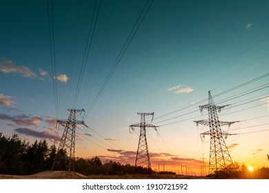 power line pylons during sunset with beautiful saturated sky. distribution, transmission and consumption of electricity