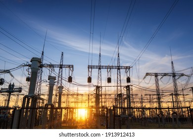 power line pylons during sunset with beautiful saturated sky. distribution, transmission and consumption of electricity - Shutterstock ID 1913912413