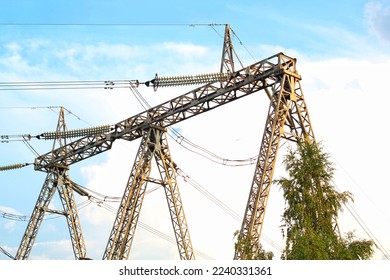 Power line station, high voltage transmission tower post tension for electricity distribution. Pylon construction with cables. Energy supply, conservation, urban industry concept. Blue sky, town city