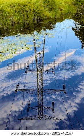 A power line tower is reflected in the waters of a DesPlaines River backwater area in DesPlaines River State Fish and Wildlife Area in Will County, Illinois